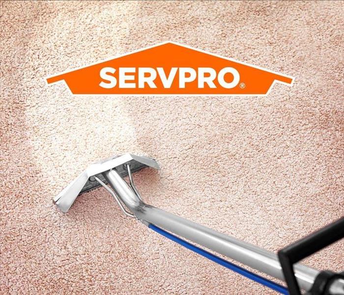 a carpet extractor being used on carpet along with the SERVPRO LOGO