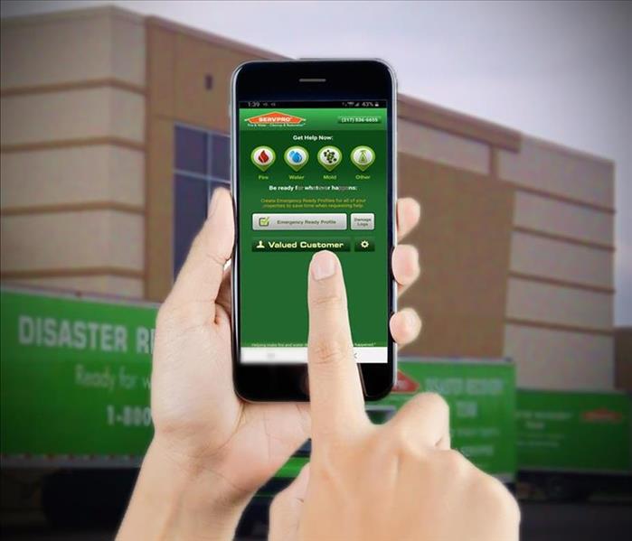 hands holding a cell phone with the SERVPRO phone app on the screen